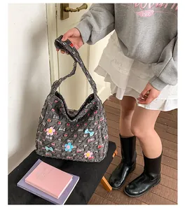 Detailansicht der dunkelgrauen Tweed-Tasche mit 3D-Blumen und Schleifenbesatz
