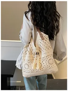 Close-up of crochet tote bag with mandala pattern, fringe tassels, and beaded drawstring