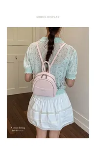 Detail of pink mini leather backpack with Aimiaten logo and metal zipper pockets