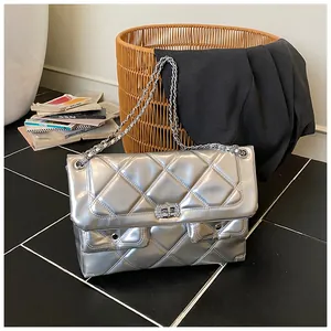Detail of silver quilted handbag with rhinestone swivel lock and metal chain strap