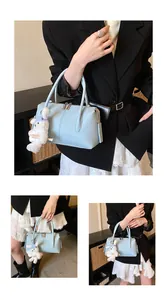 Detail of light blue boston bag featuring premium litchi texture and cute bear charm