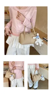 Detail of beige lychee leather pillow bag featuring a cute plush bunny charm and zipper