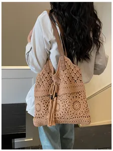 Detailed close-up of woven hollow pattern and tassel with beads on large shoulder tote