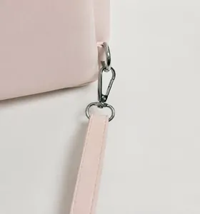 Detail of pink bag with detachable silver metal hook and adjustable shoulder strap