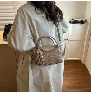 Detail view of khaki bucket bag with water ripple embossing and decorative dual tassels