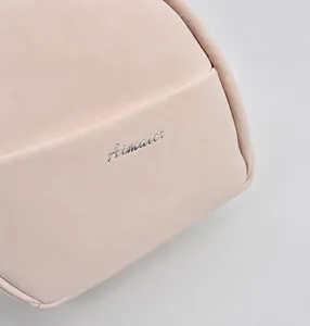 Close-up of pink mini backpack with front pocket detail and silver branded logo