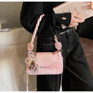Pink vintage shoulder bag with twisted woven handle and pearl charm detail macro view