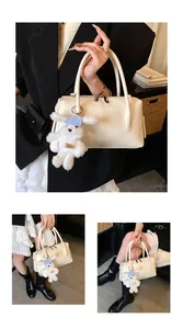 Detail of a beige pillow handbag featuring fine leather texture and a cute plush bear charm