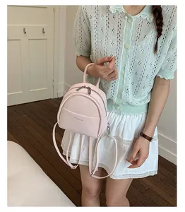 Detailed shot of a pale pink mini backpack with silver Aimaier logo and adjustable straps