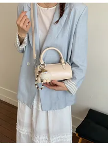 Chic cream-white cylinder handbag with creative plush charm and detachable shoulder strap
