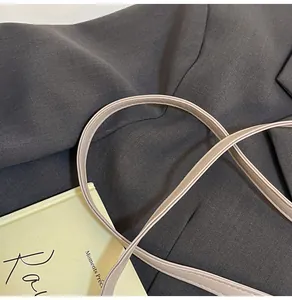 Detail shot of beige water ripple bucket bag shoulder strap with fine double stitching