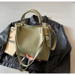 Dettaglio della borsa a secchiello in pelle verde chiaro con finiture dorate