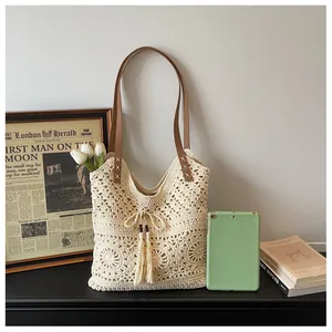 Close-up of cream crochet tote bag with fringe bow detail and brown leather straps