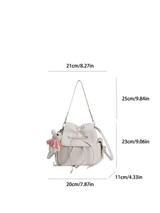 Detail view of cream PU leather bucket backpack with bow decoration and bunny pendant