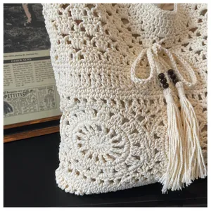 Detail of crochet tote bag featuring floral knit patterns and wooden beads with tassels