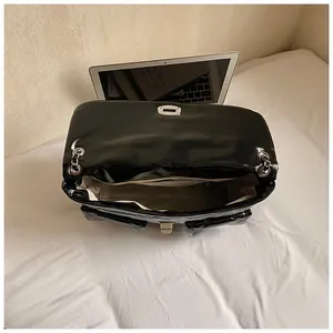 Internal view of black quilted chain bag with spacious compartment and zipper pocket