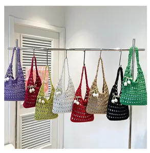 Detailed display of assorted colorful hollow knit tote bags with lily of the valley charms