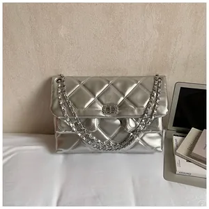 Detail of silver metallic quilted crossbody bag with luxury chain strap and metal lock