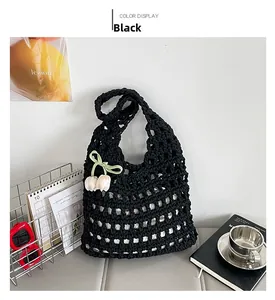 Detail of black crochet tote bag featuring light ribbon bow and tulip flower ornament