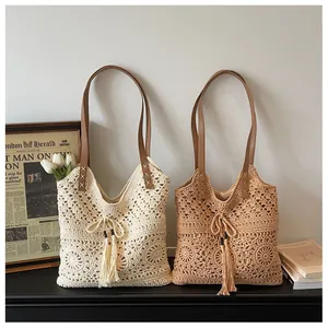 Detail of bohemian crochet tote with hollow flower patterns and tassel drawstring