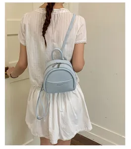 Detail of light blue mini backpack showing smooth PU leather texture and metal zipper