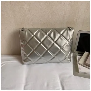 Detail of silver metallic quilted crossbody bag with stylish chain strap and sleek finish