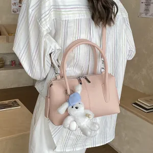 Pink minimalist bowling handbag with plush rabbit charm and adjustable shoulder strap