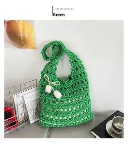 Close-up of green hand-woven tote bag with white tulip flower and ribbon detail