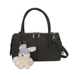 Stylish black lychee leather pillow bag with top handles and a cute bunny charm