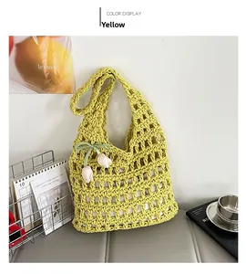 Detail of yellow handmade crochet tote bag with white tulip charms and woven texture