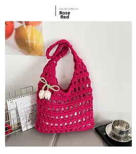 Detail of rose red hollow knit tote bag with decorative green ribbon flower charm