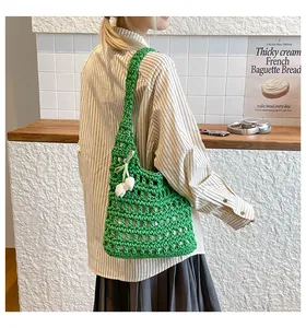 Close-up of bright green crochet tote bag with hollow knit pattern and tulip charm