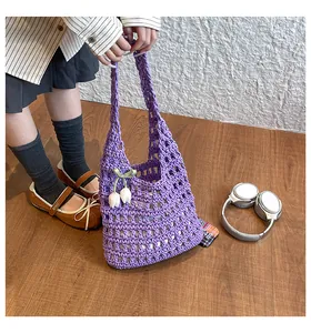 Close-up of purple crochet tote bag featuring white tulip charms and woven mesh texture