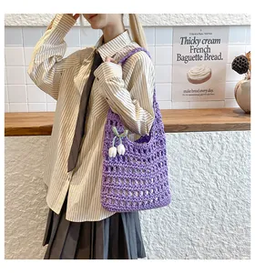 Detail of purple hand-woven crochet tote bag with tulip pendant and hollow knit texture