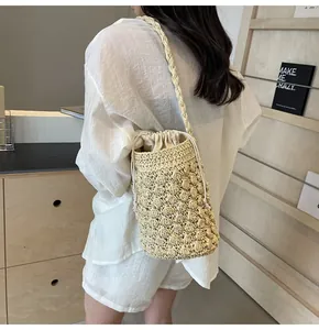 Detailed shot of a woven straw bucket bag featuring a white canvas drawstring liner