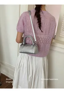 Silver metallic mini Boston bag shown with white pleated skirt for a stylish daily look