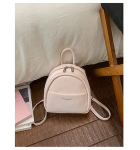 Mini beige pink faux leather backpack with adjustable straps and front pocket detail