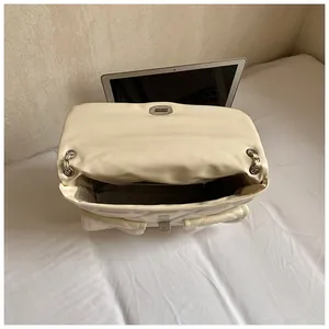 Detail view of spacious interior storage showing a laptop inside the quilted bag