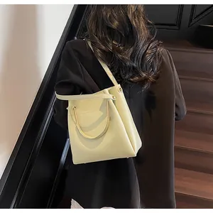 Dettaglio di una borsa a secchiello verde pallido con manico in metallo semicircolare