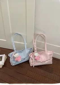 Close-up of glossy large tote bags in blue and pink with cute teddy bear pendants
