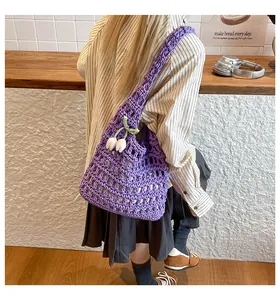 Detail of purple hand-woven crochet tote bag with a white tulip charm accessory