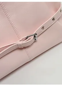 Close-up of glossy pink wrinkled leather texture and silver buckle on the tote bag