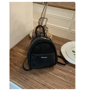 Mini black backpack in faux suede finish with white Aimaier embroidery detail