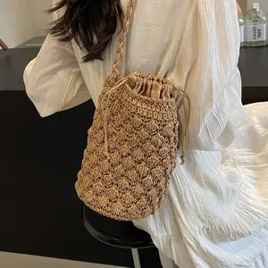 Handmade khaki woven straw bucket bag with bubble texture shown on a model