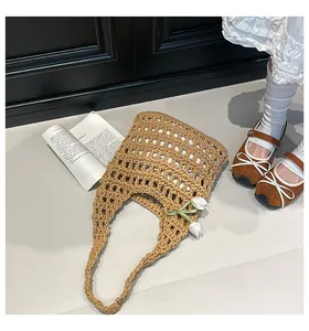 Detail of handwoven hollow tote bag featuring decorative white tulip charms and grid pattern