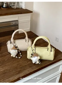 Detail of vintage mini Boston bags in beige and yellow with plush charms and bead chains