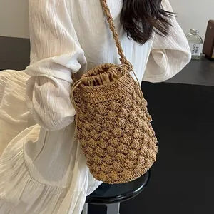 Handwoven straw bucket bag in khaki with drawstring lining and long shoulder strap