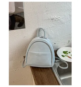 Light blue faux leather mini backpack with double zipper and embossed brand logo
