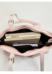 Top view of pink tote bag showing spacious black interior with zipper and daily items