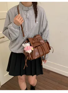 Brown faux leather backpack with bow detail and cute teddy bear charm on straps